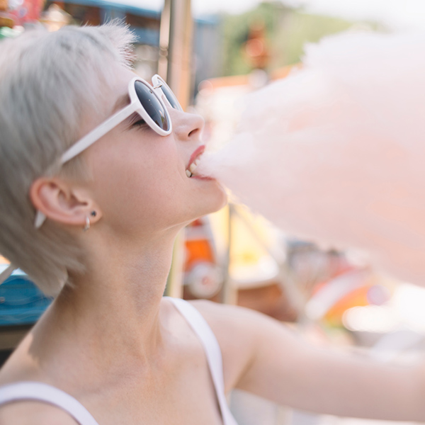 Woman with sunglasses eats candy floss
